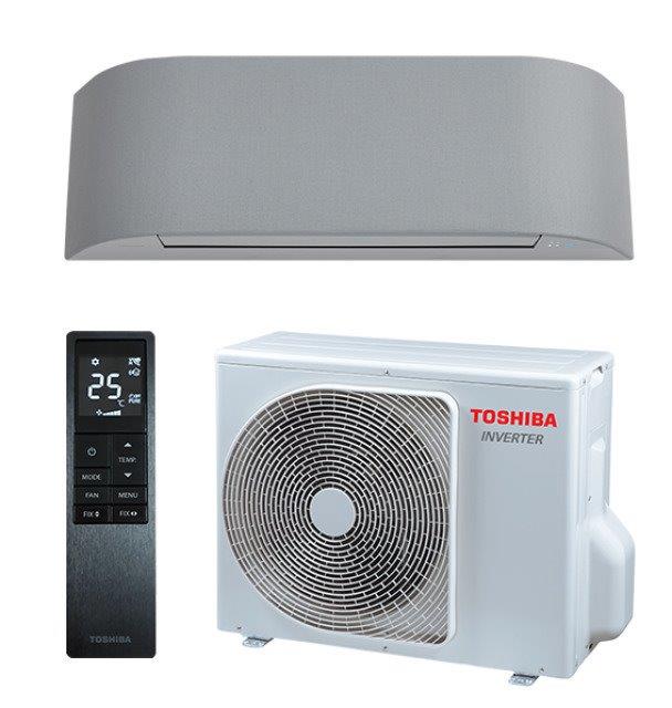 Kuvassa on Toshiba-ilmastointilaite, jossa on harmaa sisäyksikkö, valkoinen ulkoyksikkö ja musta kaukosäädin. Valo on kirkas ja tasainen.